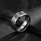 Silver ring with intricate Celtic knot design on a white background